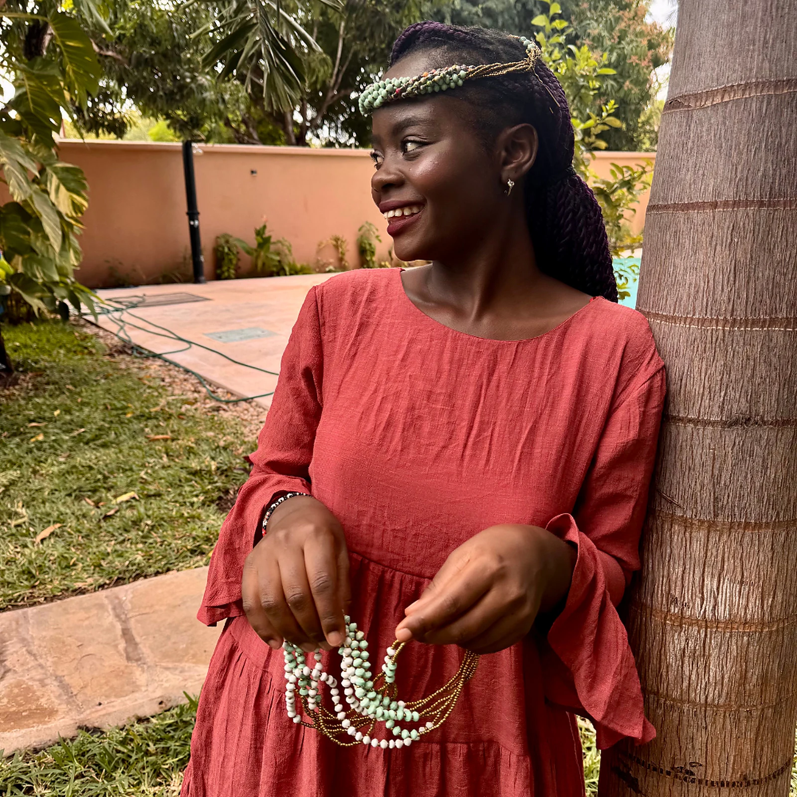 Model wearing Wamama Wetu head beads with a coral dress